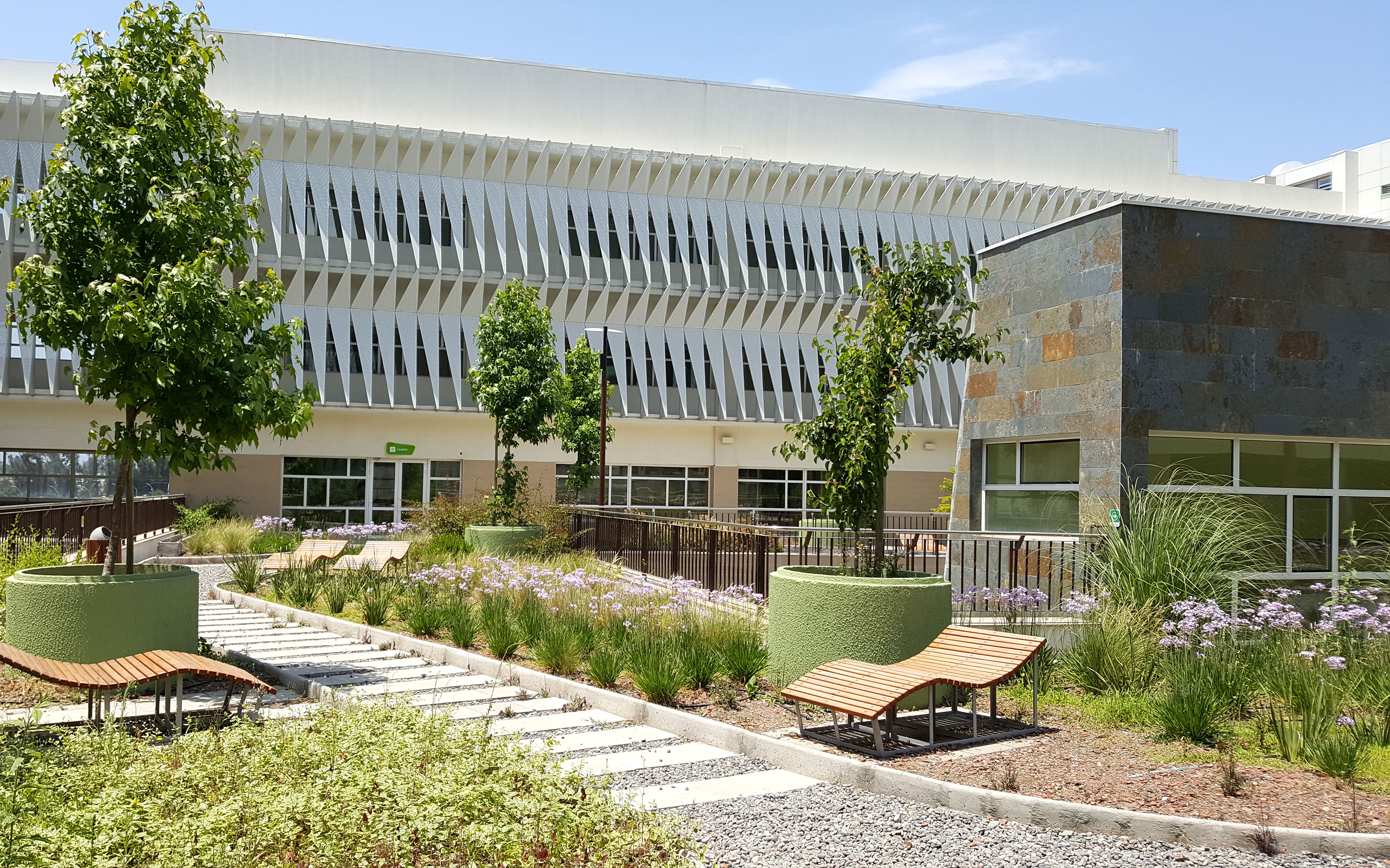 Greenery, benches and pathways to meander offer a stressful experience. Roof garden with plant beds, a gravel path and wooden loungers